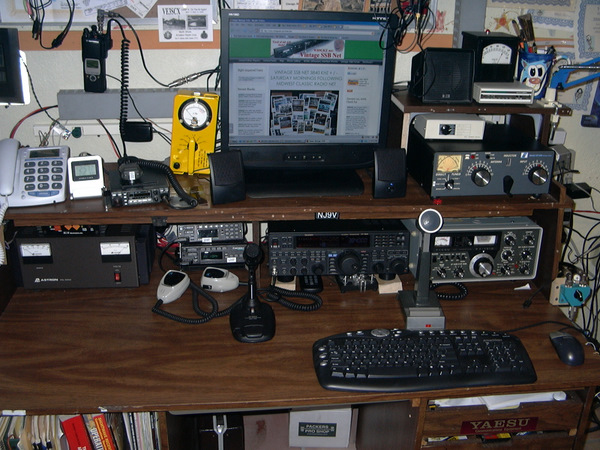 LCD Screen on shelf above operating desk showing the Vintage SSB  Web Page. On the desck itself is a linear, some sort of transistorized radios and the FT101