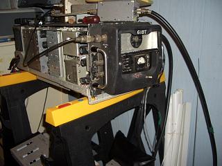 This is the heavy Collins 618T transceiver sitting on a couple of saw-horses . It is quite long but only about a foot wide and a foot tall.